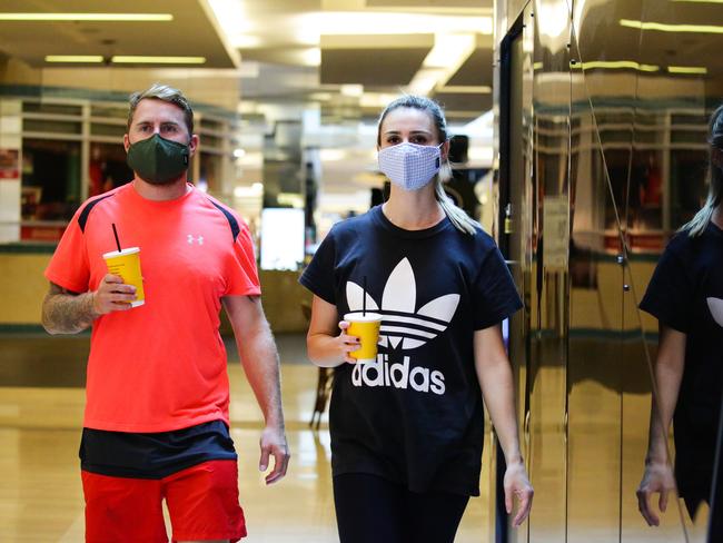 Jessica McConkey and her partner David Blackburn said they were happy to wear masks to help flatten the curve. Picture: NCA NewsWire / Gaye Gerard