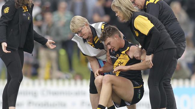 Bays utility Tom Schott is helped by trainers after suffering a knee injury. Picture: AAP Image/Dean Martin