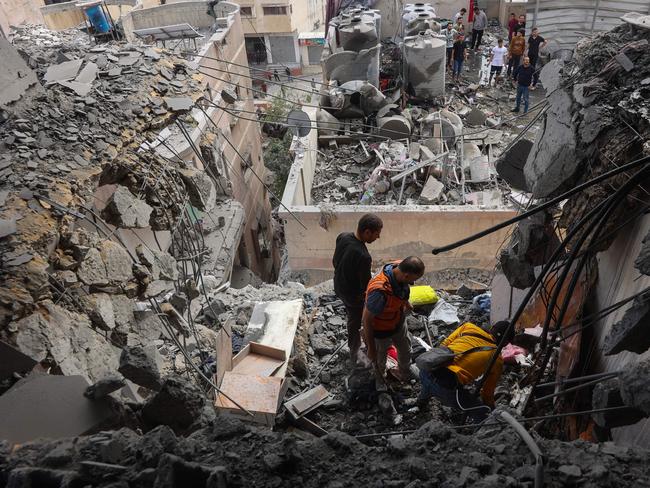 Palestinian medics search the rubble following Israeli strikes on apartments in a residential building in Gaza City's Yarmuk street on April 24, 2025. Gaza rescue teams and medics said Israeli air strikes killed at least 36 people on April 24, including a family of six whose home was struck in Gaza City. (Photo by Omar AL-QATTAA / AFP)
