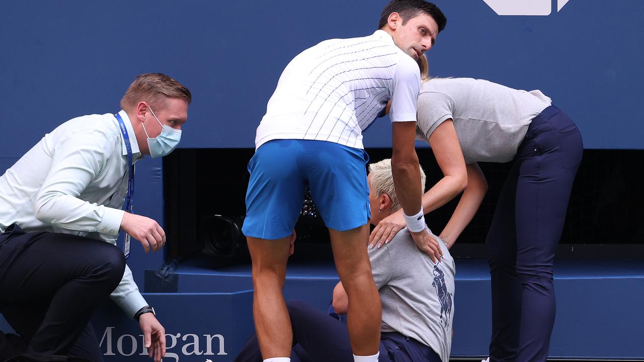 Novak Djokovic tends to a line judge who was hit with the ball. Al Bello/Getty Images/AFP