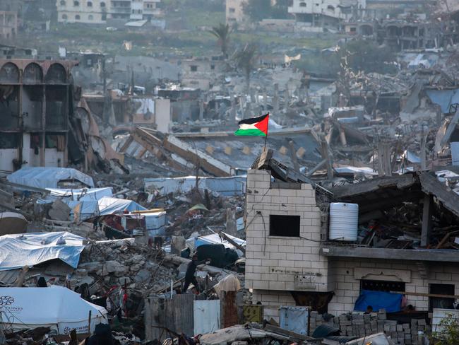 A Palestinian flag flutters amid the ruins of buildings in Beit Lahia in the northern Gaza Strip. The EU has backed an Arab plan to rebuild Gaza. Picture: AFP