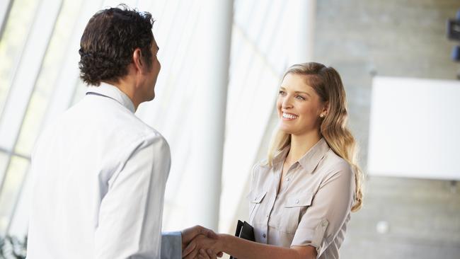 A woman starting a new job and shaking hands with a man at work. Picture: iStock.