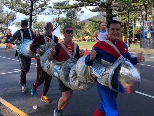 Ben Jansen, Jason Luke, Christopher Dale and Andrew Hauck break a world record at the Gold Coast Marathon for the fastest marathon run while dressed in a four-person suit. Photo: Contributed