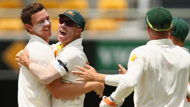 Josh Hazlewood and David Warner celebrate a wicket at the Gabba. Picture: Getty