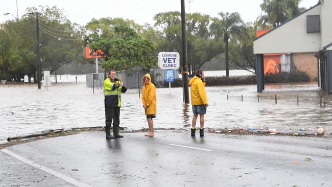 Workmen from Beaurepaires watch as their workshop fills with floodwater for the second time, March 2022. Picture: Cath Piltz