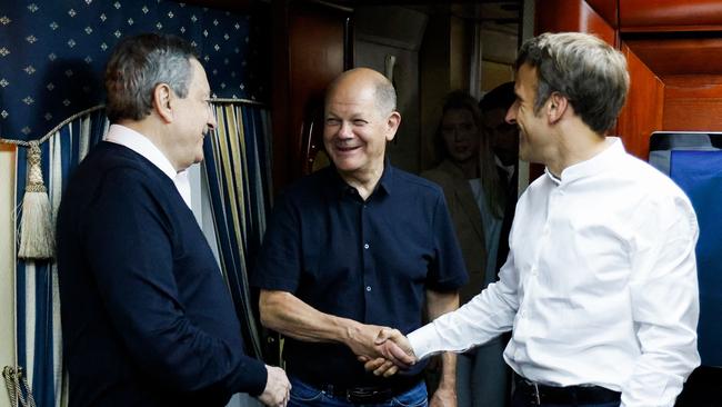 French President Emmanuel Macron, right, shakes hands with German Chancellor Olaf Scholz, next to Italian Prime Minister Mario Draghi on board a train bound to Kyiv. Picture: AFP