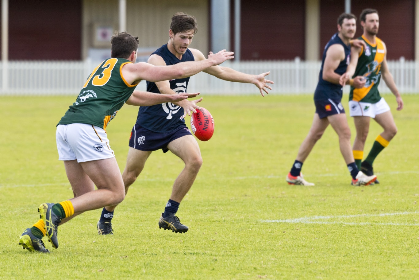 Jackson Copland kicks down field for Coolaroo under pressure from Sam Durnan of Goondiwindi in AFL Darling Downs round one at Rockville Oval, Saturday, July 11, 2020. Picture: Kevin Farmer