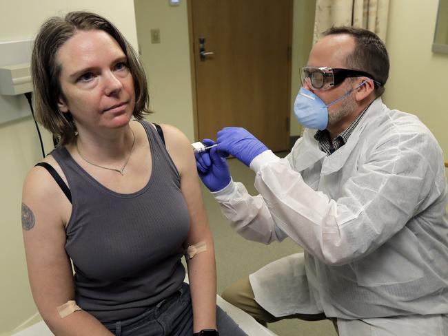 FILE - In this March 16, 2020, file photo, a pharmacist gives Jennifer Haller, left, the first shot in the first-stage safety study clinical trial of a potential vaccine for COVID-19, the disease caused by the new coronavirus, at the Kaiser Permanente Washington Health Research Institute in Seattle. The vaccine by Cambridge, Massachusetts-based Moderna Inc., generated antibodies similar to those seen in people who have recovered from COVID-19 in a study volunteers who were given either a low or medium dose. (AP Photo/Ted S. Warren, File)