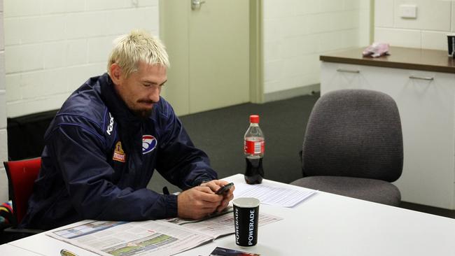 Jason Akermanis cuts a lonely figure as he sits outside the auditorium as the playing group meets after Akermanis wrote a controversial newspaper column.