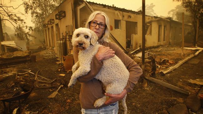 Jann Gilbert with her dog Ollie visits the site of her burnt out unit in Mallacoota. Picture: David Caird