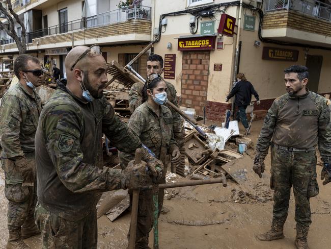 Members of the army help residents to clear mud and waste of the streets after heavy rain and flooding hit large parts of the country in the Alfafar municipality, in Valencia, Spain. Picture: Getty Images