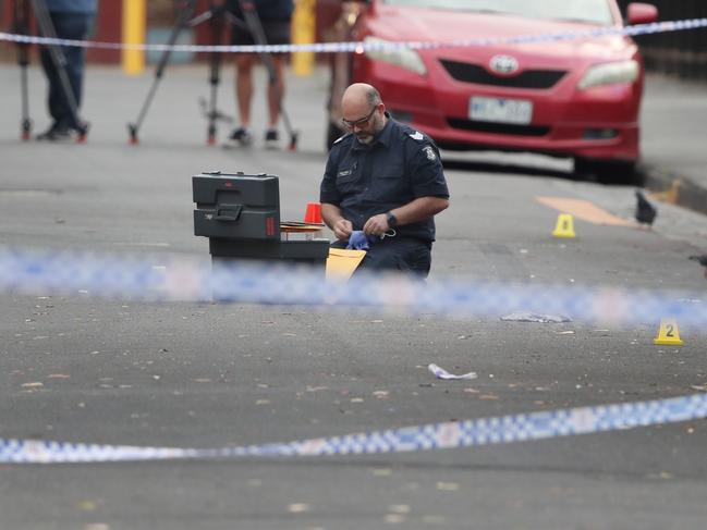 Police gather evidence on the street. Picture: David Crosling