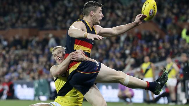 Josh Jenkins gets a kick away under pressure from Tiger Ryan Garthwaite. Picture: Sarah Reed