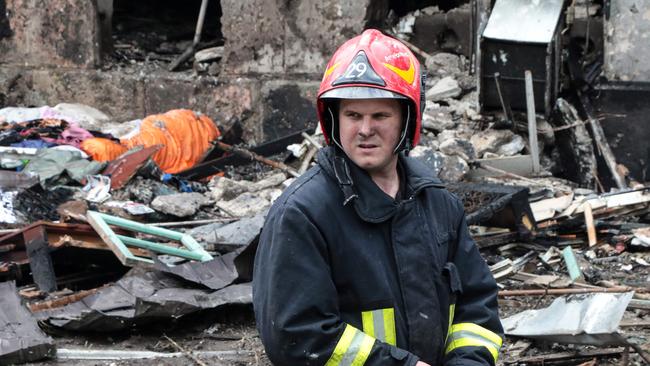 A firefighter stands in front of a destroyed five-storey residential building, following a Russian strike, in the city of Kryvyi Rig.