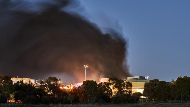 Smoke rises into the air during the fire at the Thomas Foods International abattoir. Picture: AAP / Matt Loxton