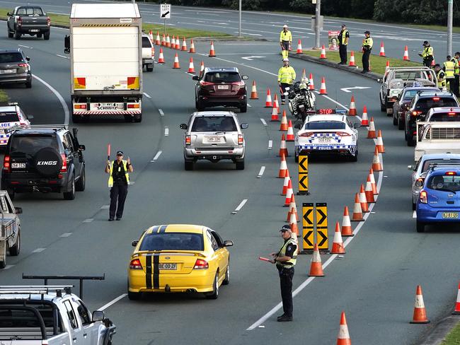 Motorists are stopped at a checkpoint on the Gold Coast Highway at Coolangatta on the Queensland/NSW border border , Thursday, March 26, 2020. The Queensland border is closed to non Queensland residents as authorities try to stop the spread of COVID-19. (AAP Image/Dave Hunt) NO ARCHIVING