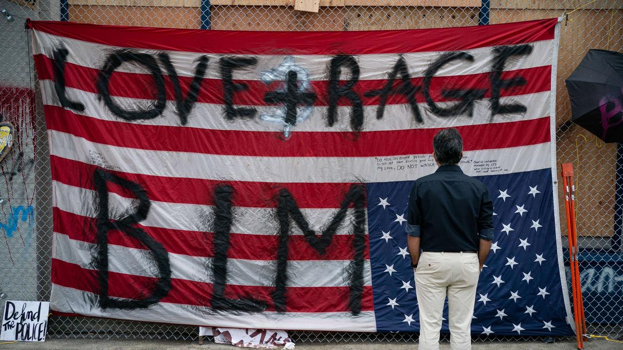 A man views an upside down U.S. flag at the Seattle Police Departments vacated East Precinct.