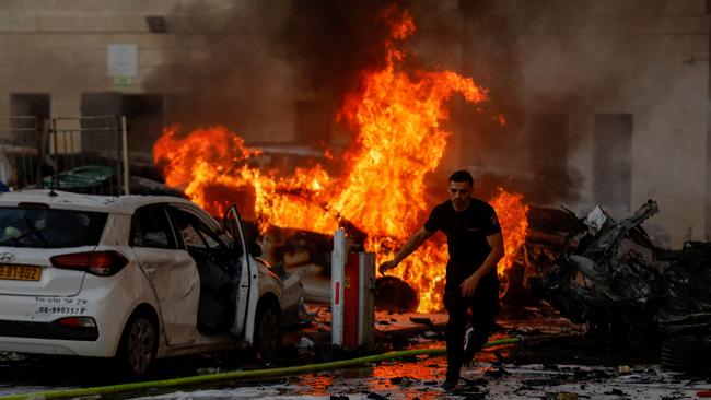 A man runs on a road as fire burns after rockets were launched from the Gaza Strip, in Ashkelon, Israel October 7, 2023. Picture: Reuters/Amir Cohen