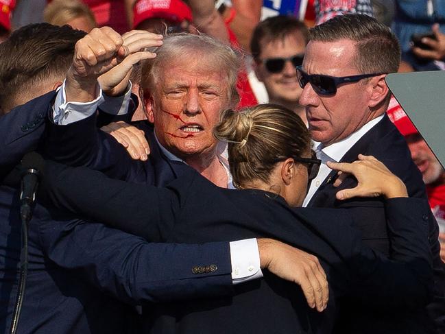 US Republican candidate Donald Trump surrounded by secret service agents as he is taken off the stage at a campaign event at Butler Farm Show Inc. in Butler, Pennsylvania. Picture: AFP