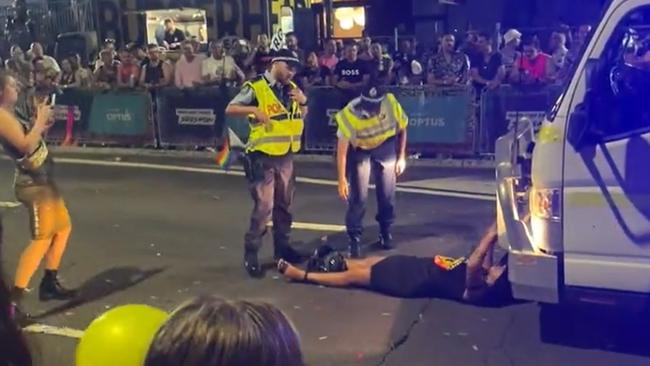 Stills from a video of Senator Lidia Thorpe who laid down in front of the Australian Federal Police float during the Sydney Mardi Gras causing a short disruption to the parade.