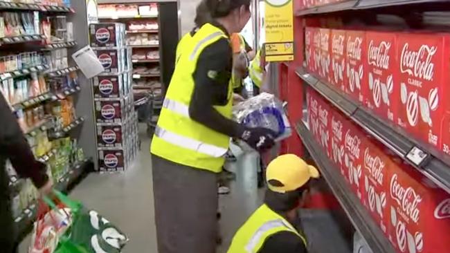 Workers rush to restock shelves in Woolworths stores returning to work after an industrial strike.