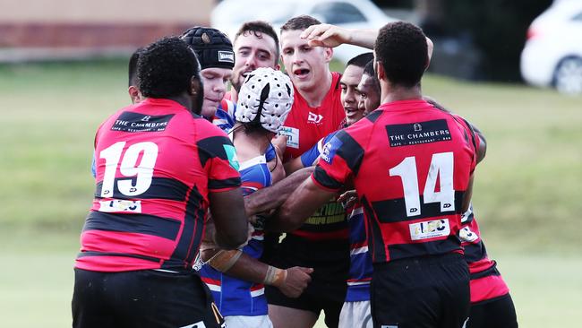 Barron Trinity Bulls players protect their teammate Kris Verevis-Brim (centre, white head gear) from Mariners players in FNQ Rugby match between the JCU Mariners and the Barron Trinity Bulls held at JCU Oval, Smithfield. PICTURE: BRENDAN RADKE