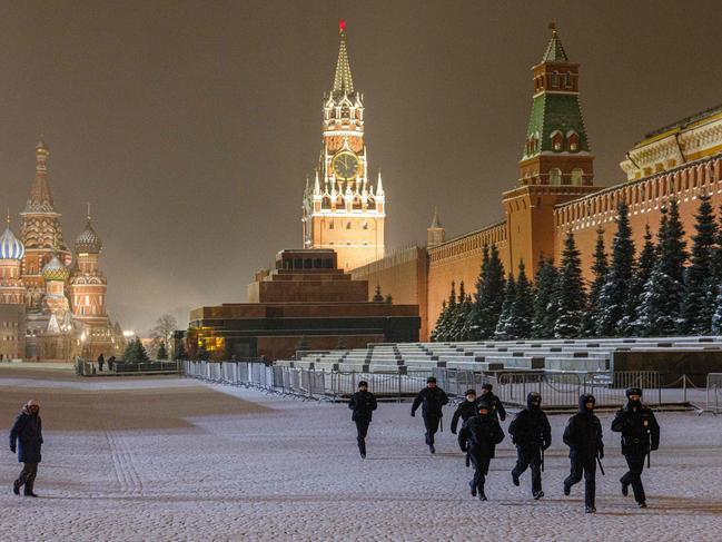 Russian police officers run through the empty Red Square during New Year's Eve in downtown Moscow. Picture: AFP