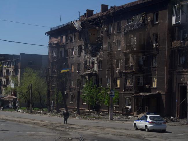 A person walks past a charred residential building in the city of Mariupol on April 29, 2022, amid the ongoing Russian military action in Ukraine. Picture: Andrey Borodulin / AFP.