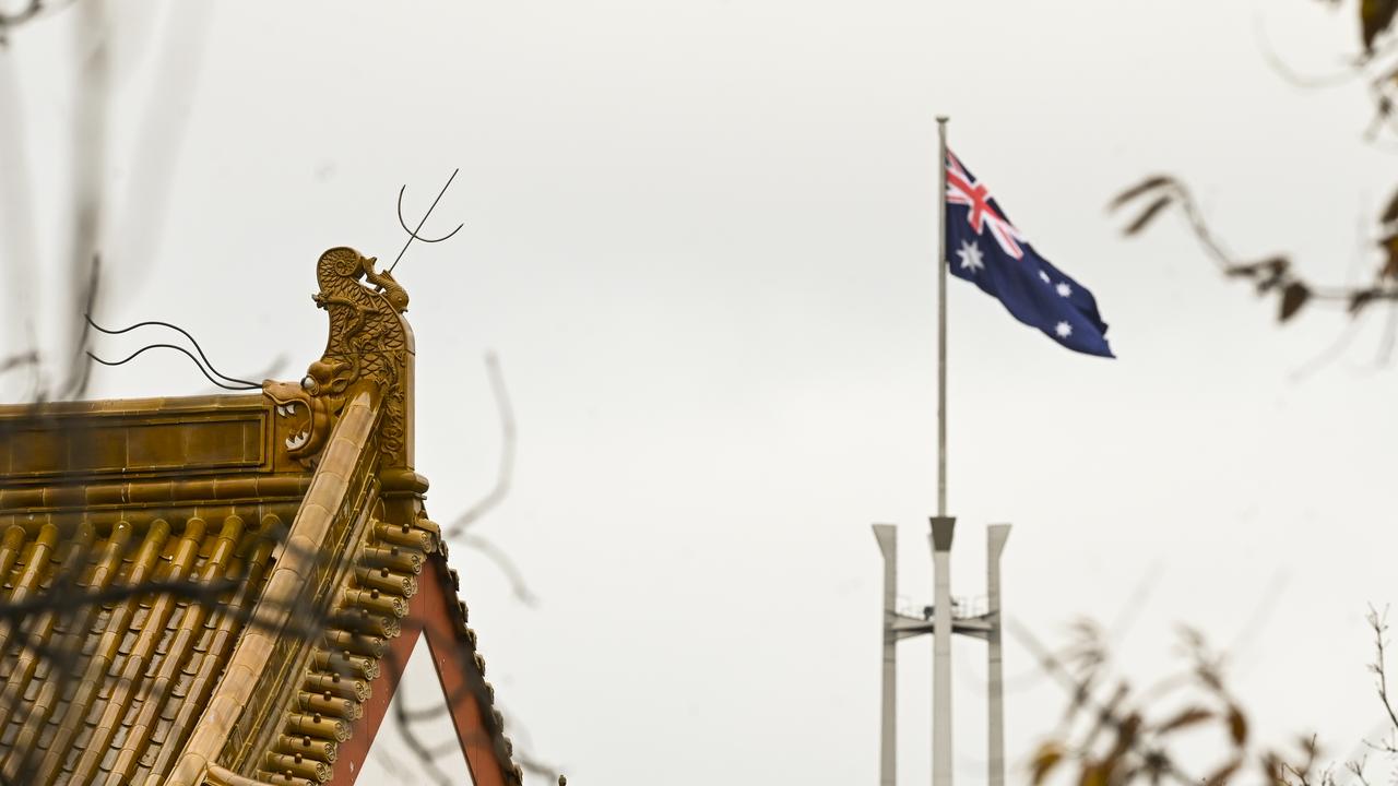 The flag pole of the Australian Parliament is seen behind the roofs of the Chinese Embassy in Canberra. Picture: AAP Image/Lukas Coch