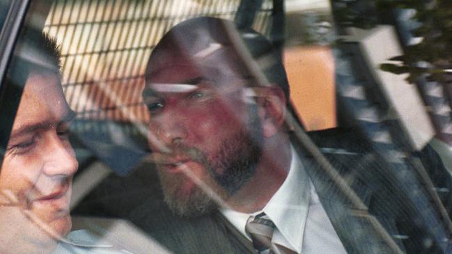 SA convicted murderer Michael Barry Fyfe (right) trying to kiss a guard on the cheek while being driven from court to Yatala Labor Prison on the February 29, 2000.