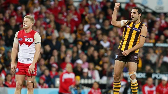 Burgoyne celebrates kicking a goal as Daniel Hannebery looks on.