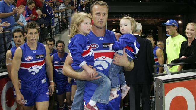 Isabella (left) with sister Sasha and dad Chris during his playing days.