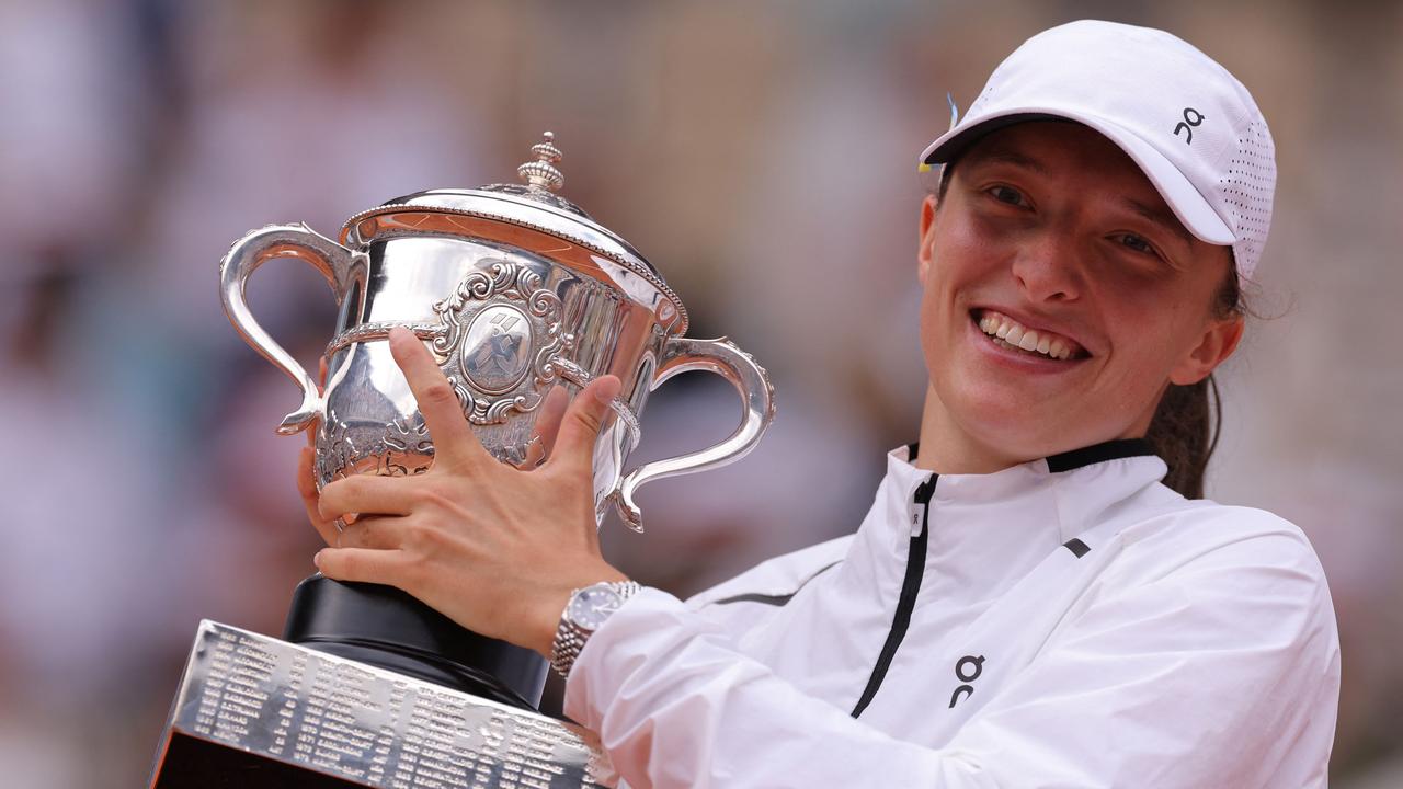 Iga Swiatek poses with the trophy. (Photo by Thomas SAMSON / AFP)