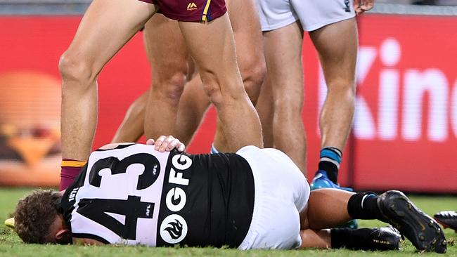 Port Adelaide’s Dan Houston hits the deck after copping a big hit at the Gabba. Picture: DAVE HUNT (AAP).