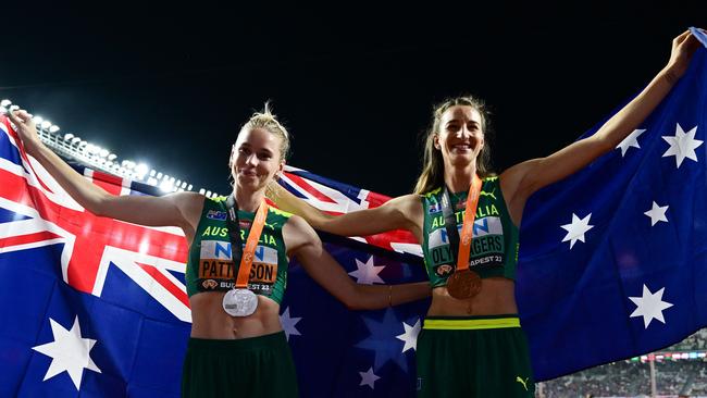 Silver medallist, Australia's Eleanor Patterson (L) and bronze medallist, Australia's Nicola Olyslagers (R) celebrate with their National flags and medals after the women's high jump final during the World Athletics Championships at the National Athletics Centre in Budapest on August 27, 2023. (Photo by Ben Stansall / AFP)