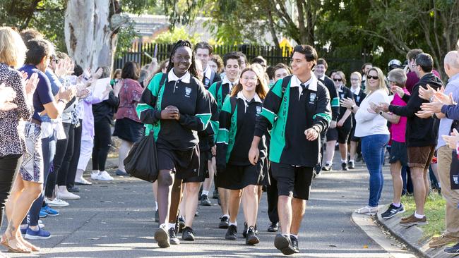 Bray Park State High School staff welcome back their year 12 students with a socially distanced guard of honour after COVID-19 restrictions are eased. Agyo Major, Tayla Pascoe and Kynan Elford lead the group into school. Picture: Renae Droop/RDW Photography