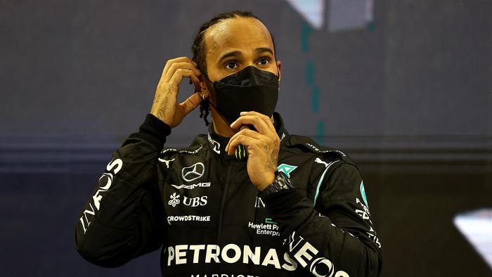 ABU DHABI, UNITED ARAB EMIRATES - DECEMBER 12: Second placed Lewis Hamilton of Great Britain and Mercedes GP looks on from the podium during the F1 Grand Prix of Abu Dhabi at Yas Marina Circuit on December 12, 2021 in Abu Dhabi, United Arab Emirates. (Photo by Bryn Lennon/Getty Images)