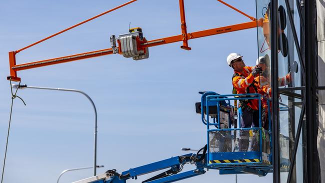 The glass panels are lifted into place at Kellyville train station.