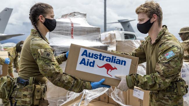 Royal Australian Flight Lieutenant Lachlan Connell passes an Australian Aid box to Private Bianca Jordan at Honiara International Airport, Solomon Islands.