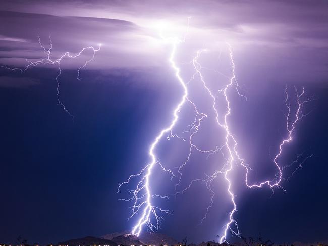 Lightning bolt storm with thunderstorm clouds at night.