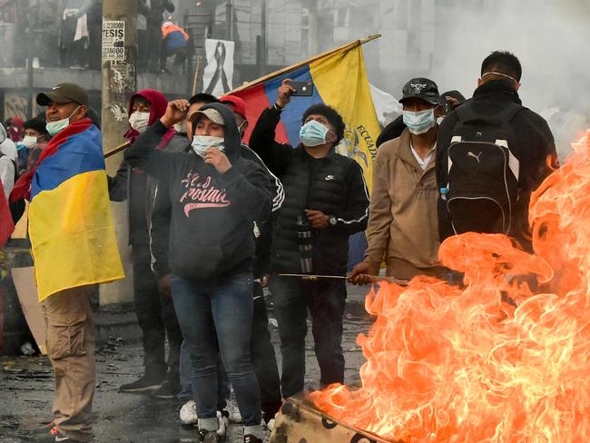 Demonstrators protest next to a bonfire outside the Casa de la Cultura (House of Culture) in Quito on October 13, 2019, as indigenous leaders prepared to meet President Lenin Moreno for face-to-face talks after nearly two weeks of violent street protests over austerity measures. - A first meeting between Ecuador's president and indigenous leaders will take place on Sunday, the United Nations said, after Lenin Moreno ordered a curfew and military control in the capital to try to quell deadly, anti-austerity protests. The rolling demonstrations have left six people dead and nearly 2,100 wounded or detained, according to authorities, with protesters on the eve targeting a television station and a newspaper as well as setting fire to the comptroller general's office. (Photo by RODRIGO BUENDIA / AFP)