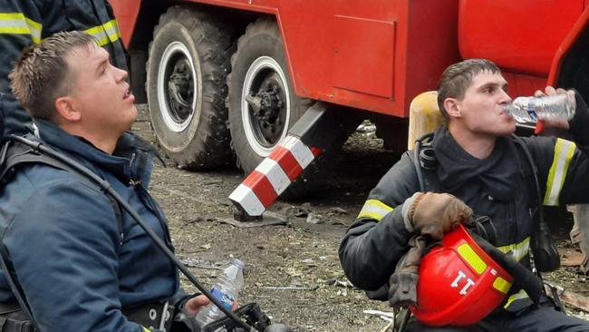 Firefighters rest during the attempt to extinguish a fire on a five-storey residential building, the site of a Russian missile strike in Kryvyi Rig. Picture: AFP