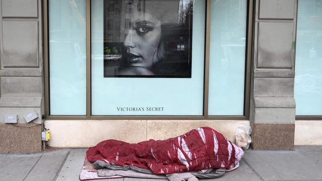 A homeless person sleeps in front of a Victoria's Secret store on the Upper West Side of New York City on February 22, 2021. The coronavirus pandemic in Manhattan's Upper West Side has caused homeless individuals to fill the streets and cramp shelters. Picture: Timothy A Clary/AFP