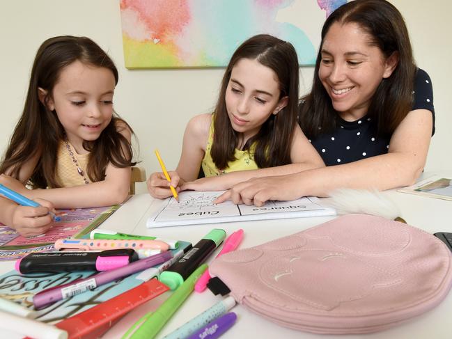 Cindi Sommers helping her daughters Bianca and Amy study at home after pulling them out of school. Picture: Tony Gough