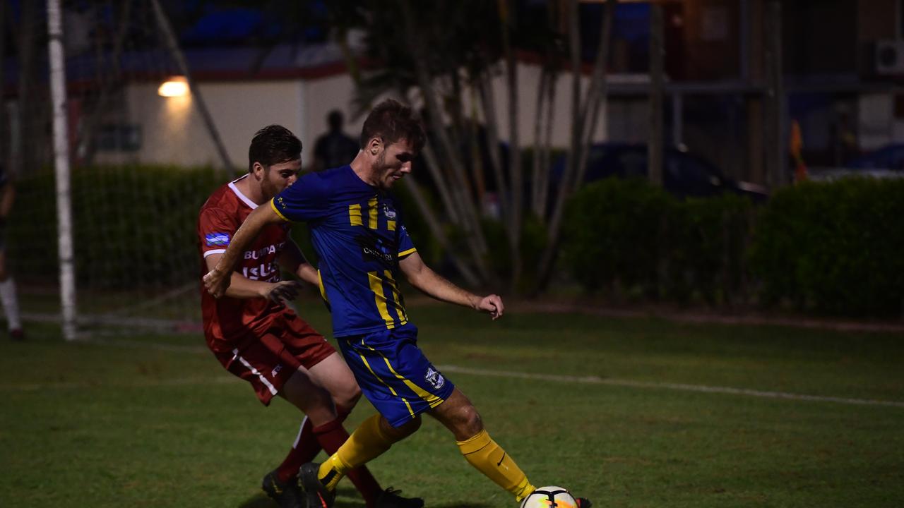 The Waves' Corey Leggett tries to beat Bargara defender Kyle Townsend during their Triple M Division 1 Cup match.