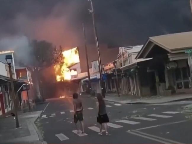 People watch a flames approach in Lahaina, Hawaii. Picture: Alan Dickar /NBC News