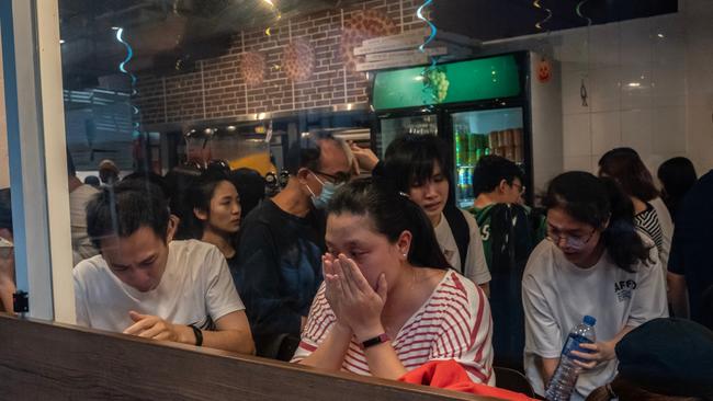 Customers shelter inside a restaurant after police fire teargas.