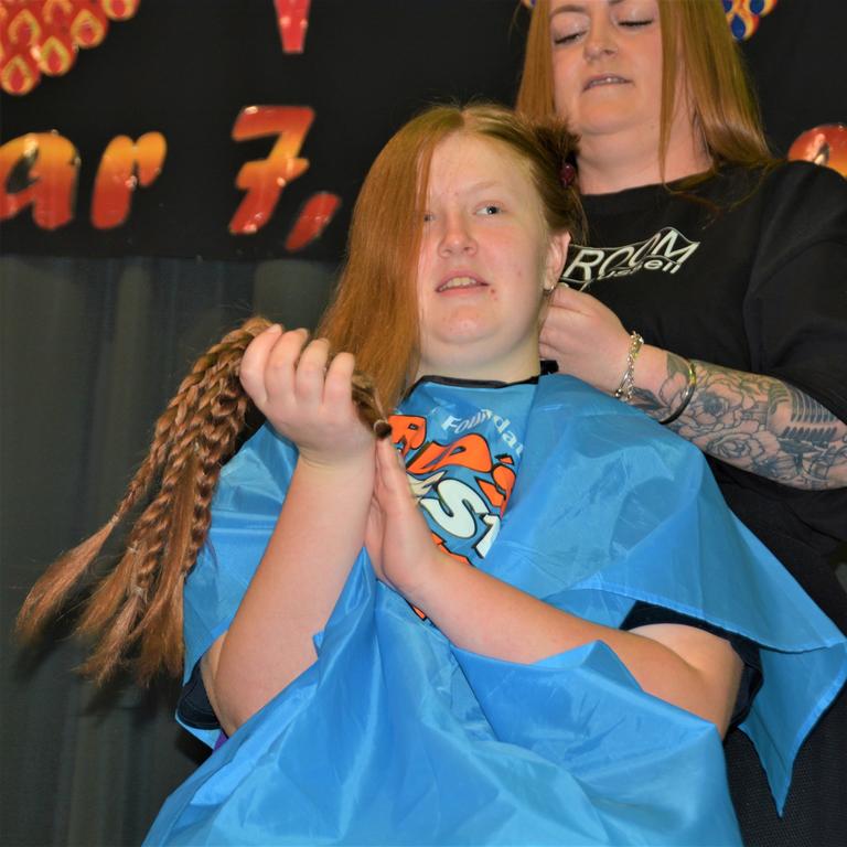 At the St Joseph's College 2023 World's Greatest Shave event is student Chelsee Kidd having her cut by her younger brother and hairdresser Rebecca Mortlock from the Hair Room on Russell. Picture: Rhylea Millar