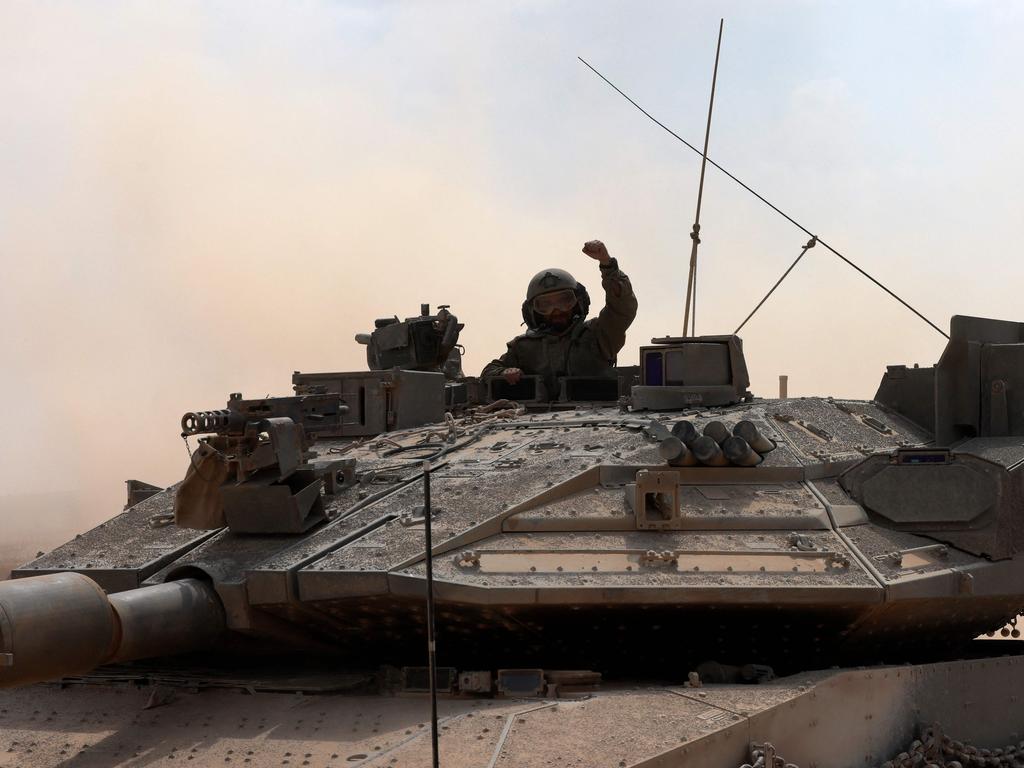 An Israeli army soldier gestures while seated in the turret hatch of Merkava battle tank. Picture: Menahem Kahana/AFP