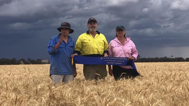 Fletcher, Rob and Mandy Taylor pictured in the winning crop of wheat at Glenalla. Picture: Supplied